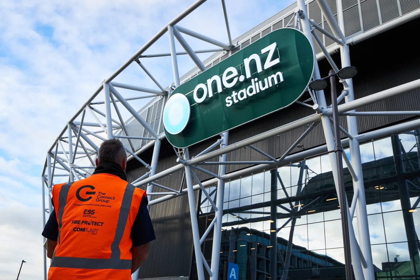 A Connect Group worker on site beneath the stadium signage